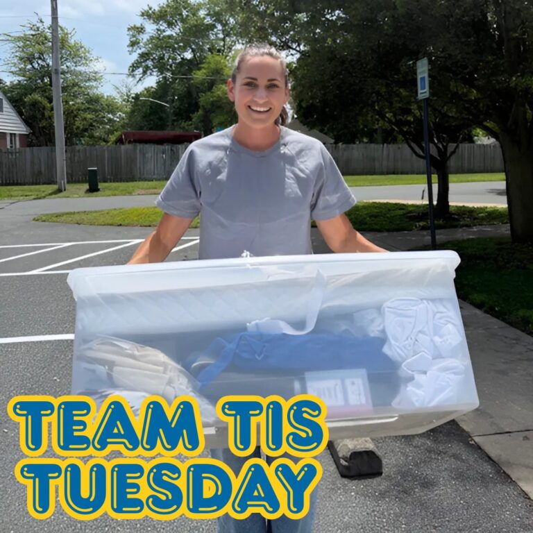 Eliza carrying a bin full of baby items