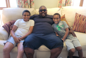 TIS guest Tyler and his two sons sitting on a couch