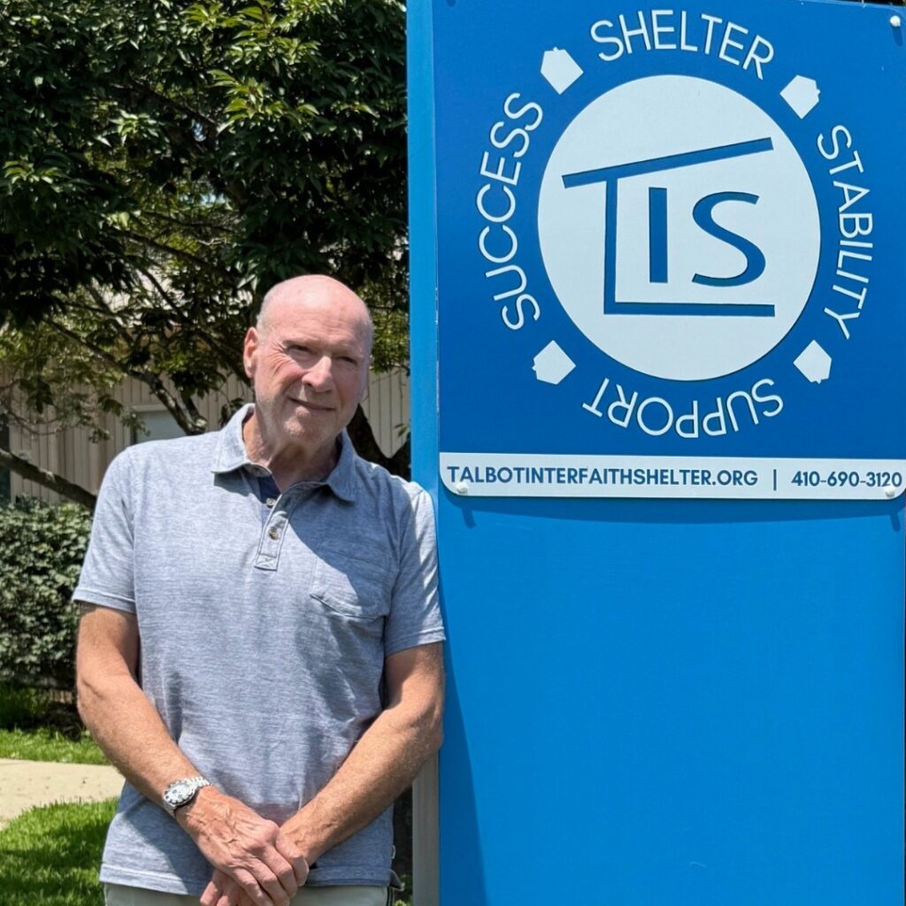Larry Neviasar posing with the TIS sign at Vine Street