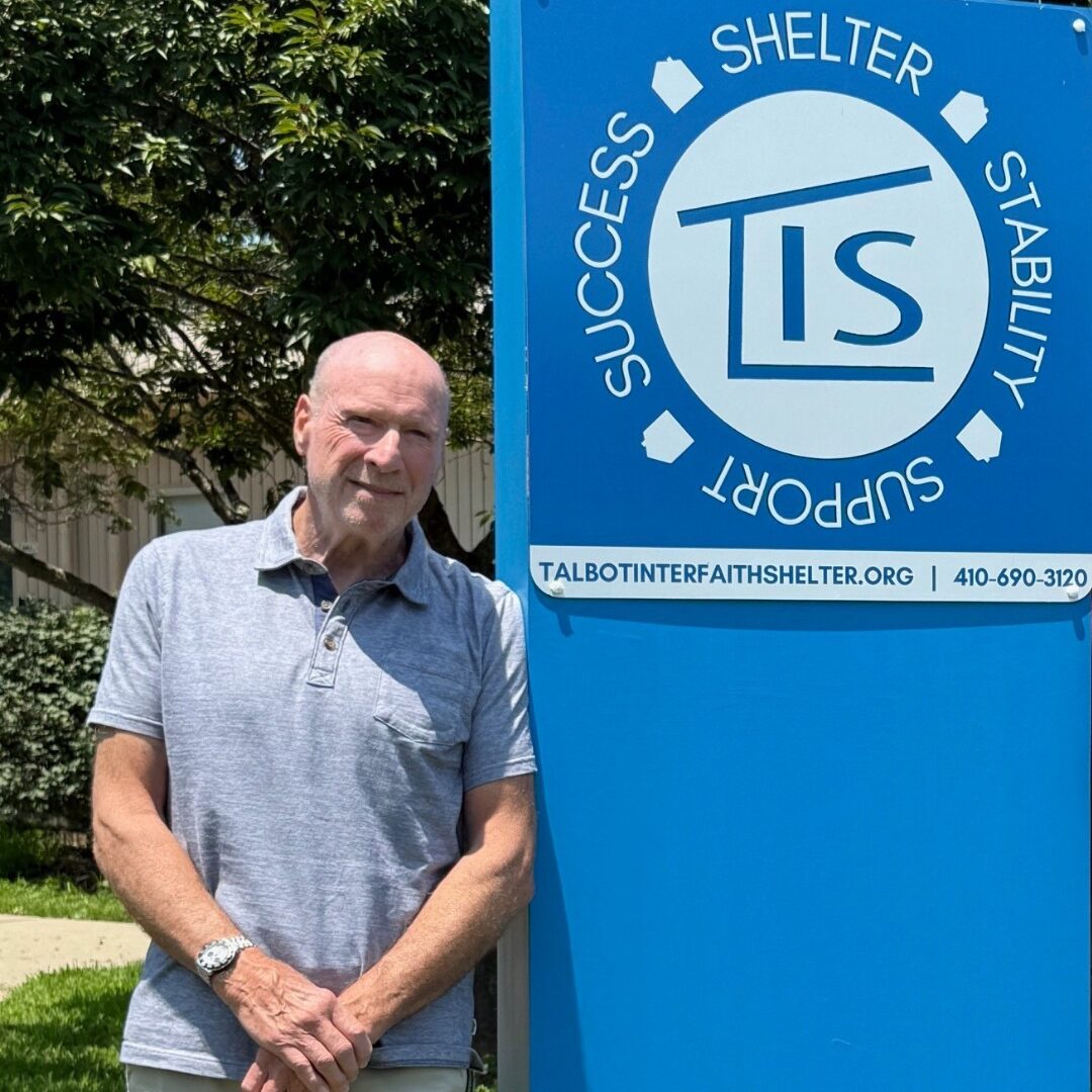 Larry Neviasar posing with the TIS sign at Vine Street