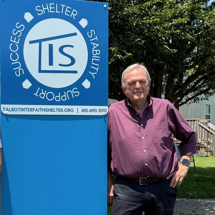 Peter Woicke posing next to the TIS sign at Vine Street