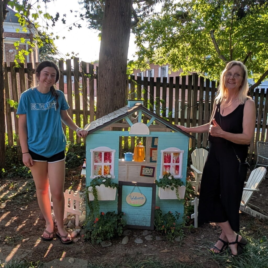 Julie Lowe with Maddie Alton in front of dollhouse