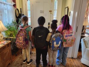 Kids facing forward wearing backpacks